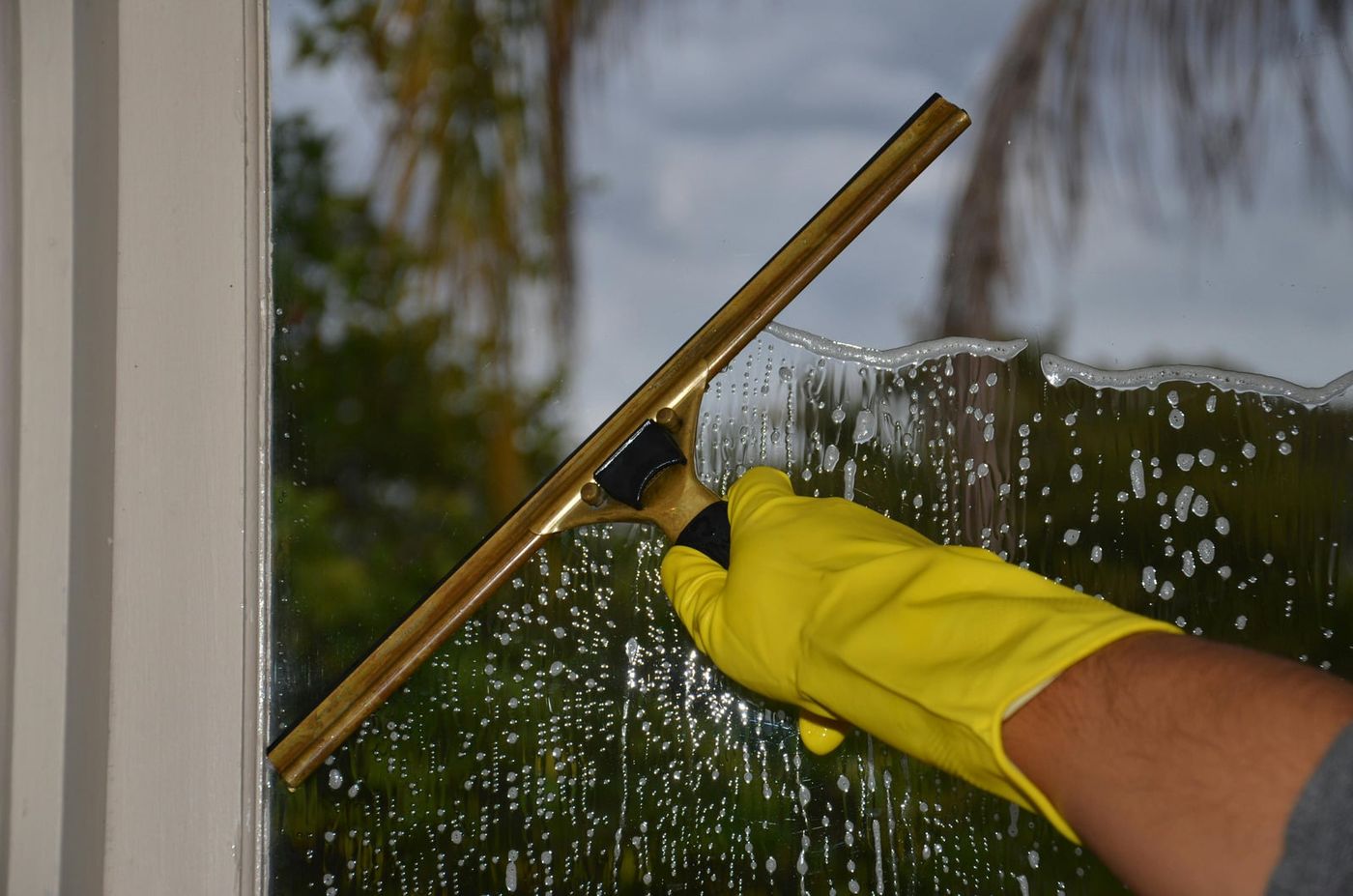Close-up of squeegee cleaning a window